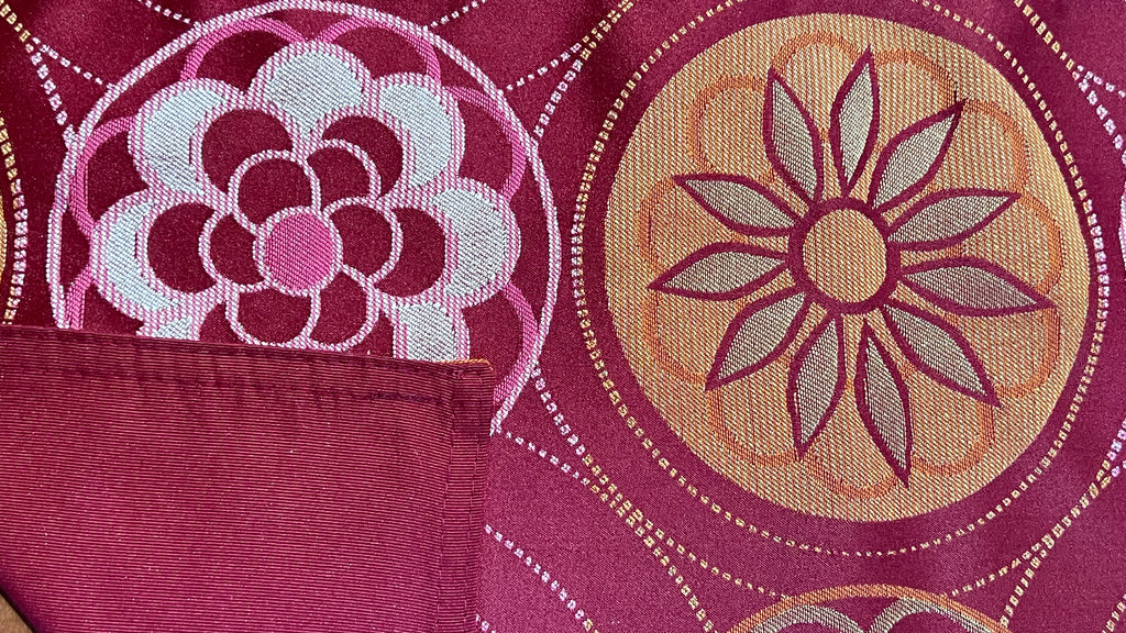 Mantel individual modelo Flores naranja vino, reverso vino.